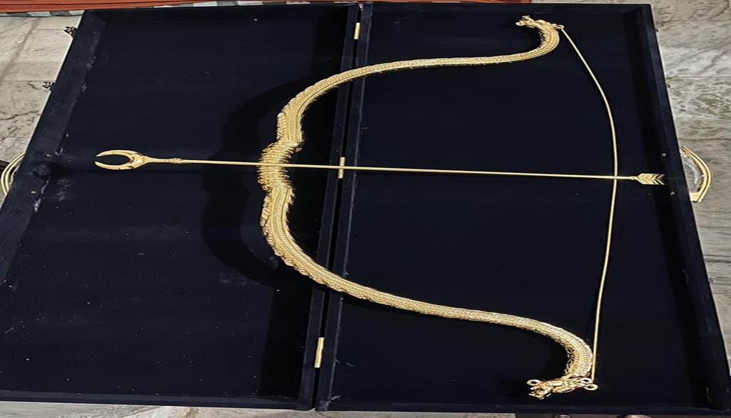 A bow and arrow adorned with gold on a copper base, symbolizing the reverence for Maryada Purushottam Lord Ram.