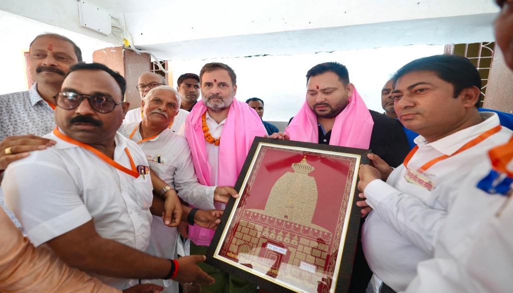Congress leader Rahul Gandhi and RJD leader Tejashwi Yadav, draped in pink stoles, receive a framed depiction of the Sun Temple during the ‘Vote Rights Yatra’ in Aurangabad, Bihar, surrounded by supporters and party workers.