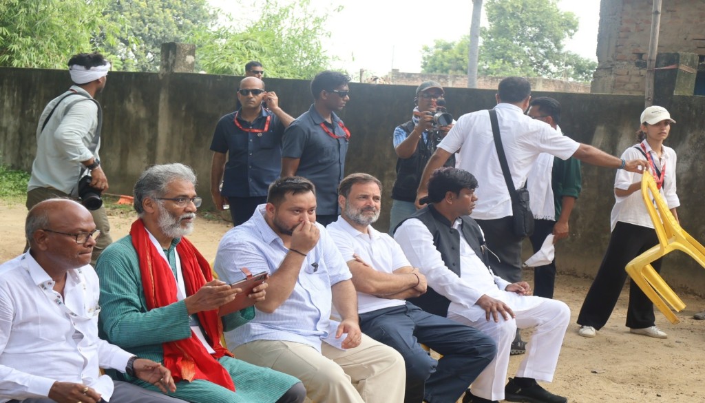 Rahul Gandhi interacts with villagers in Nawada after halting his Voter Adhikar Yatra convoy, as crowds gather and workers climb on a JCB to see him.