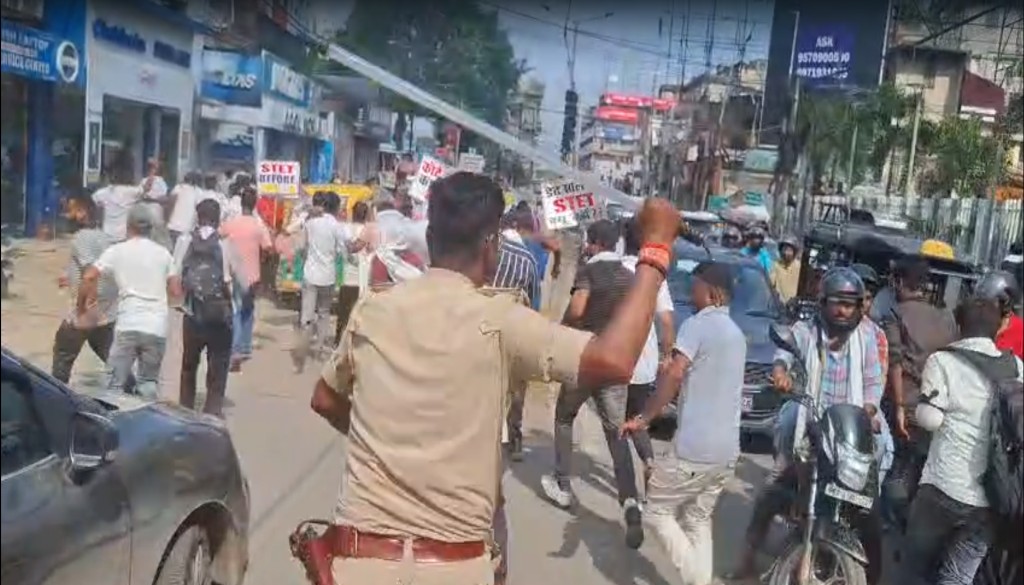 STET candidates protesting in Patna, holding banners and raising slogans, as police form a barricade and prepare to lathicharge.