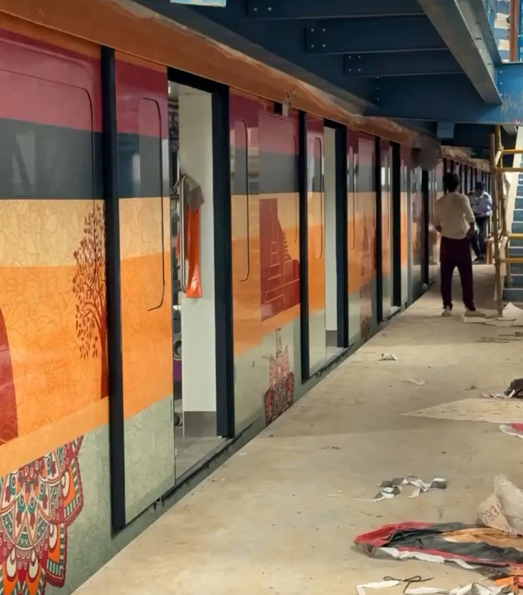 Patna Metro coach painted saffron with traditional Madhubani designs depicting Bihar’s culture and landmarks.