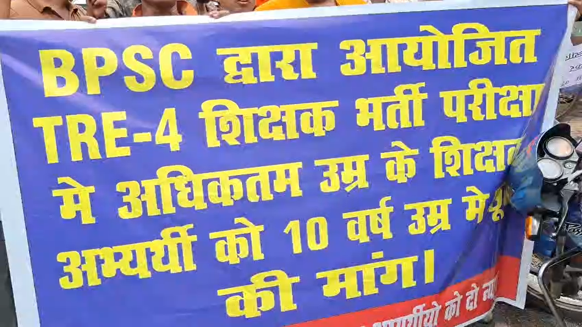 Teacher candidates protesting outside the JDU office in Patna, holding banners and raising slogans demanding a 10-year age relaxation for TRE-4 recruitment.
