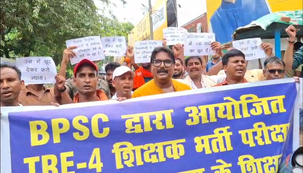 Teacher candidates protesting outside the JDU office in Patna, holding banners and raising slogans demanding a 10-year age relaxation for TRE-4 recruitment.