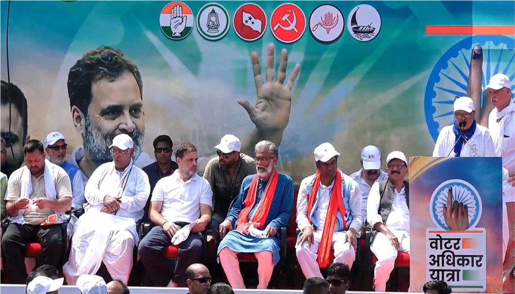 Rahul Gandhi and Tejashwi Yadav on stage at Dakbungla square during the Voter Rights March, with barricades blocking the crowd.