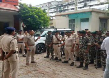 BSAP personnel armed with batons standing at a busy Patna intersection to manage protests and maintain law and order.